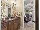 Bathroom vanity with a dark countertop, framed mirror, and overhead lighting at 6686 Se 135Th St, Summerfield, FL 34491
