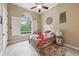 Cozy bedroom featuring a decorative window, ceiling fan and floral bedding over neutral colored floors at 6686 Se 135Th St, Summerfield, FL 34491