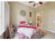 Bedroom with ceiling fan features a flower-patterned bedspread and a doorway leading to the bathroom at 6686 Se 135Th St, Summerfield, FL 34491