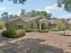 Well-maintained home featuring lush landscaping, a manicured lawn, and a circular driveway at 6686 Se 135Th St, Summerfield, FL 34491