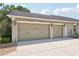 Spacious three-car garage with decorative carriage lights and a smooth concrete driveway at 6686 Se 135Th St, Summerfield, FL 34491