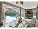 Covered patio overlooking the pool with an outdoor fireplace and seating area at 6686 Se 135Th St, Summerfield, FL 34491