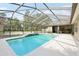 Large screened-in pool area with a beautiful waterfall feature and ample space for outdoor seating at 6686 Se 135Th St, Summerfield, FL 34491