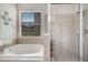 Bathroom featuring a soaking tub, a separate shower, and a large window at 6837 Pasturelands Pl, Winter Garden, FL 34787