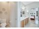 Bathroom featuring dual sinks, a toilet and an entryway to the primary bedroom at 6837 Pasturelands Pl, Winter Garden, FL 34787