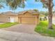 Home with two-car garage, brick paver driveway, and manicured lawn at 6837 Pasturelands Pl, Winter Garden, FL 34787
