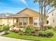 Charming home with a well-manicured front yard, flowering plants, and seating at 6837 Pasturelands Pl, Winter Garden, FL 34787