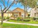 Charming home showcasing a well-manicured front lawn, landscaped garden, and inviting front porch at 6837 Pasturelands Pl, Winter Garden, FL 34787