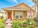 Inviting front porch featuring a cozy seating area, a decorative door wreath, and a well-kept garden at 6837 Pasturelands Pl, Winter Garden, FL 34787