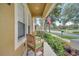 Covered front porch view with cozy seating, manicured landscaping, and view of a quiet residential street at 6837 Pasturelands Pl, Winter Garden, FL 34787