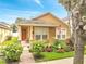 Charming single-story home featuring a landscaped front yard, quaint porch, and inviting red door at 6837 Pasturelands Pl, Winter Garden, FL 34787
