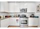 Well-lit kitchen showcasing stainless steel appliances, light cabinets and granite countertops at 6837 Pasturelands Pl, Winter Garden, FL 34787