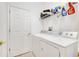 Bright laundry room with washer, dryer, and overhead storage at 6837 Pasturelands Pl, Winter Garden, FL 34787
