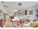 Open-concept living room with hardwood floors, decorative ceiling fixtures and a colorful area rug at 6837 Pasturelands Pl, Winter Garden, FL 34787