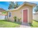 Exterior shot of the shed features matching siding, a brick walkway, and a pink door at 6837 Pasturelands Pl, Winter Garden, FL 34787