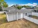 Rear exterior of a gray home with a white privacy fence surrounding the yard and a small brick landing at 731 Guernsey St, Orlando, FL 32804