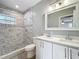 Bathroom with double vanity, quartz counters, walk-in shower, and stylish black and white tile at 731 Guernsey St, Orlando, FL 32804