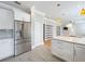 Open kitchen view showcasing white cabinets, stainless steel refrigerator, quartz countertops, and hardwood floors at 731 Guernsey St, Orlando, FL 32804