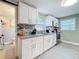 Bright kitchen with white cabinets, granite countertops, and stainless steel appliances at 731 Guernsey St, Orlando, FL 32804