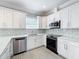 Updated kitchen features white cabinets, quartz countertops, stainless steel appliances, and subway tile backsplash at 731 Guernsey St, Orlando, FL 32804