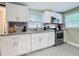 Bright kitchen with white cabinets, granite countertops, and stainless steel appliances at 731 Guernsey St, Orlando, FL 32804