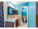 Bright bathroom featuring blue walls, tile flooring, vanity, sink and mirror at 7616 Southwick St, Orlando, FL 32818
