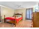 Bedroom with a wooden bed frame, ceiling fan, wood laminate flooring and colorful bedding at 7616 Southwick St, Orlando, FL 32818