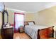 A simple bedroom features a small window with a sheer curtain, twin bed and dresser at 7616 Southwick St, Orlando, FL 32818