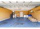 Spacious two car garage with blue painted floor, lounger, and overhead lighting at 7616 Southwick St, Orlando, FL 32818