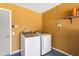 Well-lit laundry area with side by side washer and dryer and yellow walls at 7616 Southwick St, Orlando, FL 32818