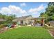 Spacious backyard featuring a well-manicured lawn, a fire pit, and a covered outdoor seating area at 811 Wayne Ave, Altamonte Springs, FL 32701