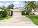 Suburban home with a two-car garage, mature landscaping, and a long driveway at 811 Wayne Ave, Altamonte Springs, FL 32701