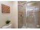 Tiled bathroom featuring glass shower, decorative artwork and neutral colored walls at 8941 Bismarck Palm Rd, Kissimmee, FL 34747