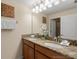 Bathroom featuring dual sinks, granite countertops, and a large mirror at 8941 Bismarck Palm Rd, Kissimmee, FL 34747