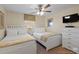 Bedroom with two beds, ceiling fan, window, dresser, and neutral decor at 8941 Bismarck Palm Rd, Kissimmee, FL 34747