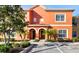 Charming two-story townhouse with a stucco facade, arched entrances, palm trees, and well-maintained landscaping at 8941 Bismarck Palm Rd, Kissimmee, FL 34747