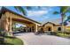 Stately clubhouse exterior featuring a porte cochere, columns, and well-maintained landscaping at 8941 Bismarck Palm Rd, Kissimmee, FL 34747