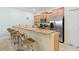 Charming kitchen with a breakfast bar, granite countertops, and stainless steel appliances at 8941 Bismarck Palm Rd, Kissimmee, FL 34747