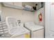 Modern laundry room with washer, dryer, shelving and laundry basket for convenience at 8941 Bismarck Palm Rd, Kissimmee, FL 34747