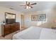 Comfortable bedroom featuring a TV, ceiling fan, window, and dresser at 8941 Bismarck Palm Rd, Kissimmee, FL 34747