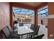 Covered outdoor patio with a glass table, cushioned chairs and pool in the background at 8941 Bismarck Palm Rd, Kissimmee, FL 34747