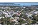 Aerial view of a residential area with tree-lined streets, showcasing a mix of homes and commercial buildings at 9169 Harris Hawk Dr, Leesburg, FL 34788