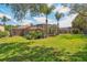 Backyard featuring a screened pool enclosure, mature palm trees, and a green lawn at 10161 Sandy Marsh Ln, Orlando, FL 32832