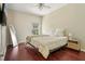 Bright bedroom with wood floors, ceiling fan, large mirror, and a window overlooking greenery at 10161 Sandy Marsh Ln, Orlando, FL 32832