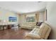 Well-lit living room with hardwood floors, a large sectional sofa, and a flat-screen TV at 10161 Sandy Marsh Ln, Orlando, FL 32832