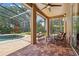 Covered patio with brick pavers, seating area, and view of the pool and landscaped backyard at 10161 Sandy Marsh Ln, Orlando, FL 32832