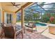 Screened patio area with brick pavers and a pool surrounded by tropical landscaping at 10161 Sandy Marsh Ln, Orlando, FL 32832