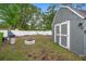 Landscaped backyard with a stone fire pit, shed, and white fencing at 1094 Henry Balch Dr, Orlando, FL 32810