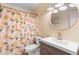 Stylish bathroom featuring a modern vanity, round mirror, and a colorful shower curtain at 1094 Henry Balch Dr, Orlando, FL 32810