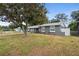 Charming single-story home featuring a well-manicured lawn and mature trees on a sunny day at 1094 Henry Balch Dr, Orlando, FL 32810